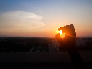 Beautiful sunset, silhouette touch the sun, image of finger catch the sun and evening sky, Silhouette Hands catching the falling sun during sunset.