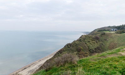 landscape with steep North Sea coast, cloudy day, gray sky