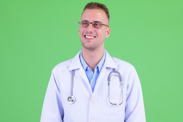 Face of happy handsome man doctor with eyeglasses thinking