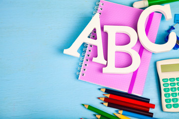 Items for the school and letters ABC on a wooden table.