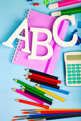 Items for the school and letters ABC on a wooden table.