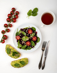 Healthy vegetarian food. Salad with beetroot, spinach, cherry tomatoes and seeds.