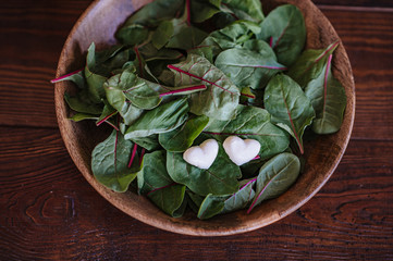 Fresh salad mix of baby spinach, arugula leaves, basil, chard and lambs lettuce. Salad bowl, healthy food, top view