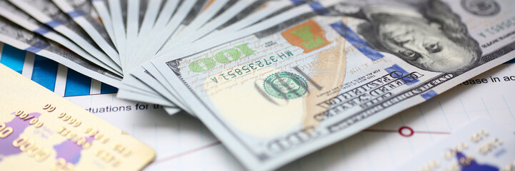 Obraz premium Big amount of US currency on financial statistics graphs closeup