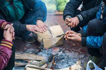 Hands of rural minority people warming up around the fire during the cold weather days in mountaious region in Vietnam