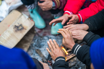 Hands of rural minority people warming up around the fire during the cold weather days in mountaious region in Vietnam