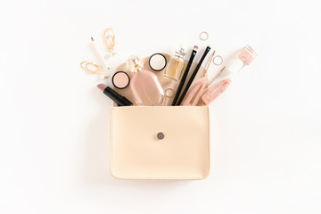 Composition with women's cosmetics and accessories in handbag on white background