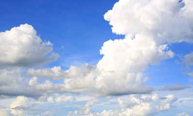 Blue sky background with puffy clouds.