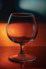 A glass on the table, in the reflection of the bottle.