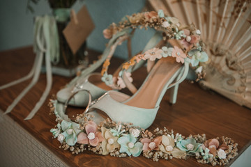 Bride's bouquet and shoes on a table.