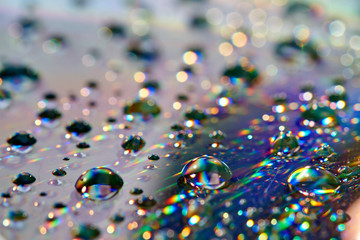 Water drops with reflection of the rainbow. Colorful abstract background. Blue, green and red abstract rainbow background. Closeup, selective focus