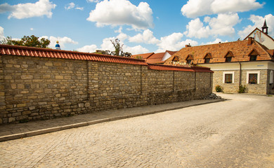 Fototapeta na wymiar Ukrainian old city back street alley way with stone wall paves road and monastery small building in colorful day time and clear weather 