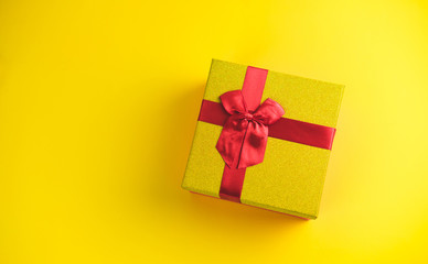 Gift box on sunny yellow background. The concept of the New Year, Christmas, Birthday, Anniversary. Top view. Flatlay.