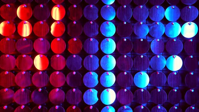Shiny kinetic surface panel illuminated by red and purple light in luxury boutique. Flickering background for interruptions or text savers. Mirror sequins sway by wind blowing.
