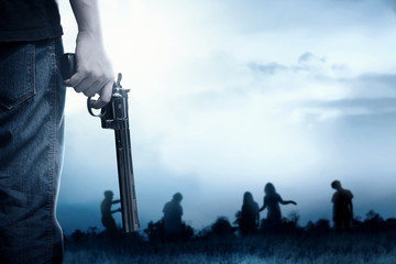 People with a gun on his hand face the zombies on the grass field