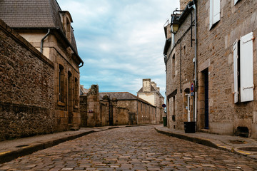 Stone medieval houses in cobblestoned street in Dinan