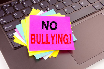 Writing text showing No Bullying made in the office with surroundings such as laptop, marker, pen....