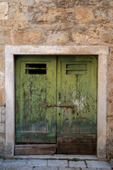 Fototapeta na wymiar Cracked vintage green door at old town