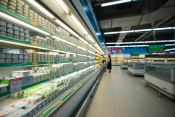 Supermarket blurred background with colorful shelves and unrecognizable customers