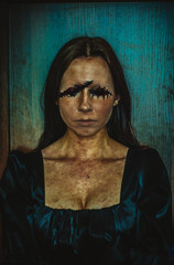 Creepy portrait of young woman without eyes on rough azure background