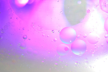 Water and oil, beautiful color abstract background based on blue, neon, and orange circles and ovals, macro abstraction.