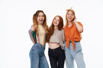 Obraz premium Portrait of three beautiful girls wearing casual clothes smiling and posing at camera together