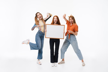 Portrait of three joyous girls wearing casual clothes smiling and holding copyspace frame together