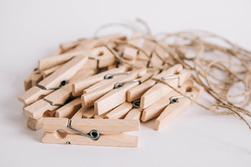Wooden clothespins with rope on white background. View from above. Place for your text