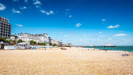Eastbourne, Sussex, UK. A summer view of the pebble beach at the East Sussex town on the south coast of England with the landmark bandstand and pier in view.
