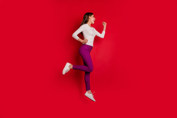 Fototapeta na wymiar Full length body size photo of joyful encouraged nice cute girlfriend running towards shopping mall because there are discounts while isolated with red background