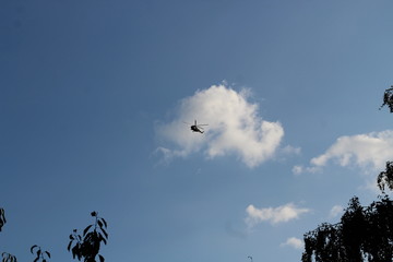large military helicopter hovers in sky. A camouflaged helicopter flies at high speed.