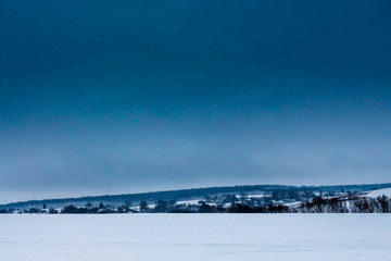 Fototapeta na wymiar Winter landscape with snowy field and dark blue sky_