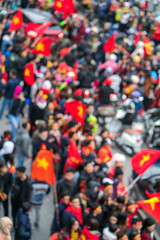 Obraz premium Blurred background of crowd of Vietnamese football fans down the street to celebrate the win after soccer, with a lot of Vietnamese flags raising high