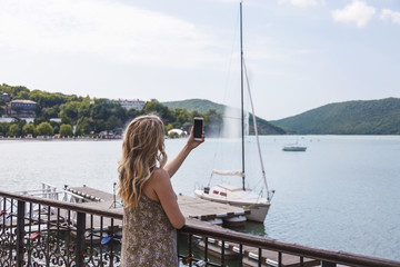 girl blogger traveler takes pictures on smartphone