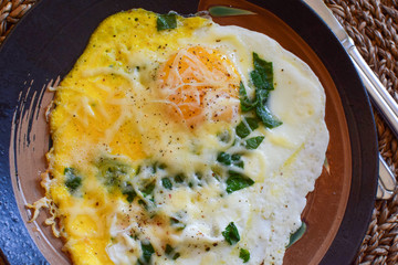 Fried eggs with green spinach and grated cheese. 