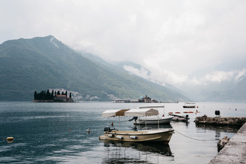 Beautiful view of the Bay of Kotor in Montenegro near the city of Perast. In the background there is an island with a church in the sea and in the foreground are many boats.