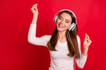 Photo of cute girlfriend listening to music with her new earphones while isolated with red...