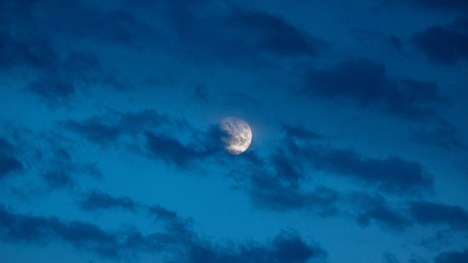 Der Mond hinter den Wolken am Abend
