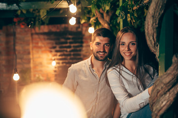 portrait of young happy couple, outdoor posing, moody night scene