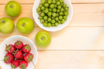 Natural organic food background with copy space. Fruits and berries on wooden table.
