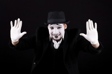 mime shows theatrical emotions on black background