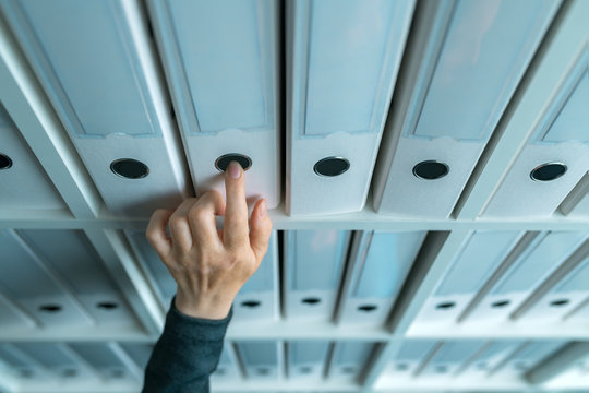 Businesswoman browsing through ring binder file documentation archives