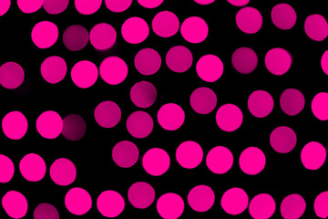 Unfocused abstract pink bokeh on black background. defocused and blurred many round light
