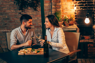 young couple making toast with wine, at home in garden, evening scene