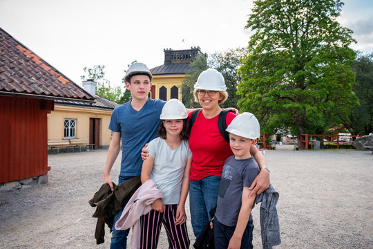 Outdoor family portrait of a single mother and children wearing white hard hats. Preparation for underground exploration.
