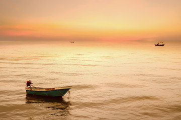 Naklejka premium Beautiful dramatic atmosphere of twilight sky and sea with fisherman's boats in summer tropical season.