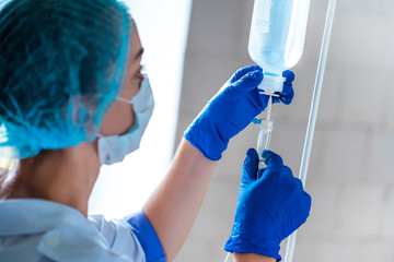 Nurse preparing drop counter to a patient for procedure in hospital