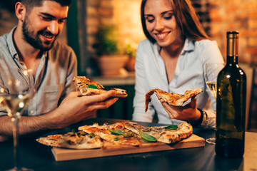closeup of friends eating pizza