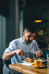 young man eating alone in restaurant