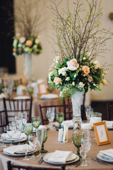 Beautiful composition with flowers on the tables and candles for guests at a wedding or a birthday party